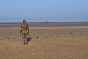 a man walking on a beach with a surfboard at Aberley House in Liverpool