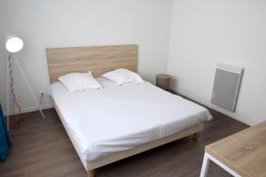 1 dormitorio con 1 cama grande con sábanas blancas en Résidence UXCO H2O, en La Rochelle