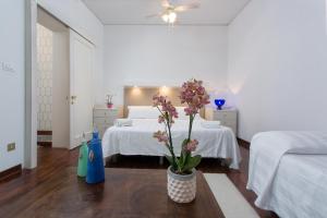 a bedroom with two beds and a vase with flowers on a table at Ca Dama del Pozzo in Venice