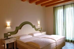 ein Schlafzimmer mit einem großen Bett und einem großen Fenster in der Unterkunft Agriturismo Le Vai in Bardolino