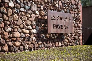 Una pared de piedra con un cartel que lee el casino rakyam Fair en Le Palais Paysan, en Oumnas