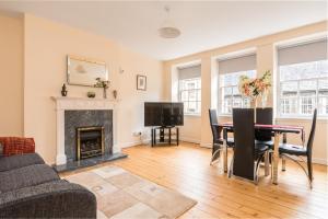 a living room with a table and a fireplace at Sunny & spacious Royal Mile apt dating from 1677 in Edinburgh