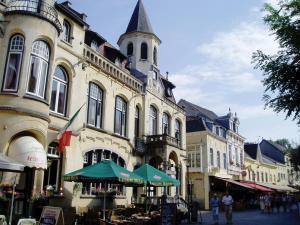 a large building with a clock tower on a street at Fletcher Hotel Valkenburg in Valkenburg