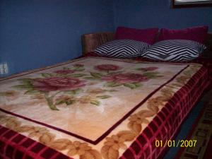 a bed with a blanket with flowers on it at Pansion Stari Konak in Sarajevo