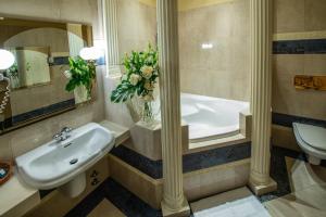 a bathroom with a sink and a bath tub at Hotel Royal in Gliwice