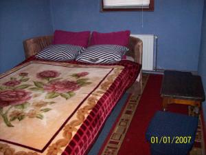 a bed in a room with a couch with pillows at Pansion Stari Konak in Sarajevo