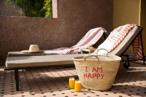 a room with two beds and a basket with words law happy at Le Palais Paysan in Oumnas