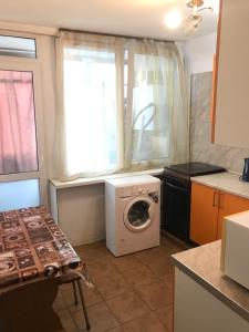 モスクワにあるアパートメント G クヴァルタル レニングラーツキーのキッチン(洗濯機付)、窓が備わります。