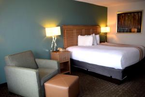 
a hotel room with two beds and a chair at Chestnut Tree Inn - Cherokee in Cherokee
