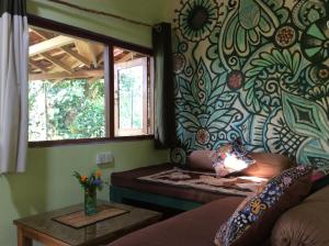 salon z kanapą i oknem w obiekcie Natural Mystic Sanctuary w mieście Deniyaya