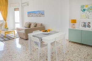 sala de estar con mesa blanca y sillas en Appartamento La Finestra sul mare, en Pozzallo