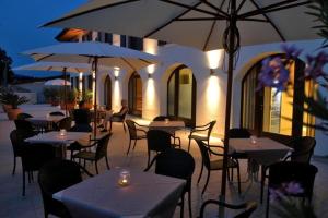 a restaurant with tables and chairs and umbrellas at Agriturismo Le Vai in Bardolino