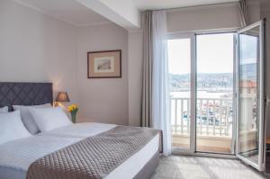 a bedroom with a bed and a large window at Hotel Marina in Izola