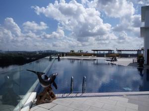 a swimming pool with a dolphin statue next to a building at Bayu Marina Residence 3 Mins away Mid Valley Southkey in Johor Bahru