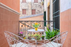 un balcone con due sedie e un tavolo con fiori di Venetian Infinity a Venezia