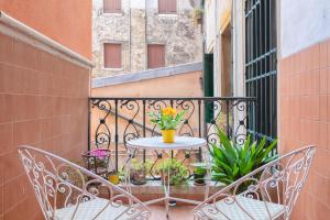 a balcony with two chairs and a table with flowers at Venetian Infinity in Venice
