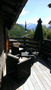 a deck with chairs and an umbrella and a view of mountains at La Source des Diounes in Besse