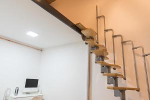 a set of stairs in a room with a computer on the wall at New Loft Style Appartman in the heart of the City in Budapest