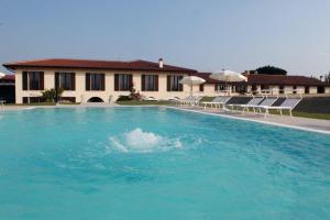 a large swimming pool with chairs and a building at Agriturismo Le Vai in Bardolino