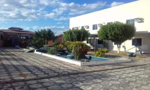a courtyard with trees and a white building at Sun Valley Hotel in Campo do Meio