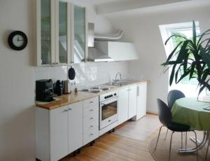 eine Küche mit weißen Schränken und einem Tisch mit einer Pflanze in der Unterkunft NetteMaisonette in Saarbrücken