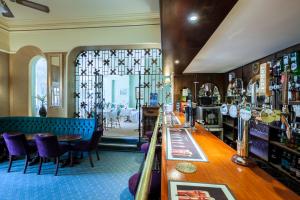The Hotel Balmoral - Adults Only في توركواي: وجود بار في مطعم تتوفر فيه الكراسي الأرجوانية والطاولات