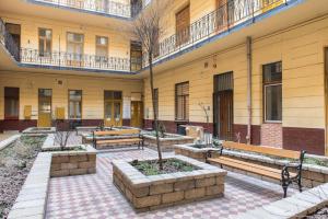 a courtyard with benches in front of a building at New Loft Style Appartman in the heart of the City in Budapest