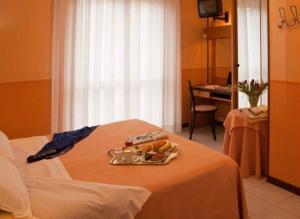 a room with a bed with a tray of food on it at Giardino Hotel in Milan