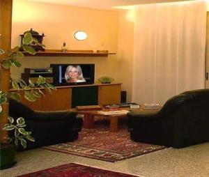a living room with a tv and a table at Giardino Hotel in Milan