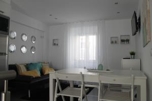 uma cozinha e sala de estar com mesa e cadeiras em Cantinho das Flores II em Nazaré