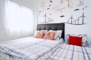 1 dormitorio con 1 cama con almohadas de color naranja y molinos de viento en Setapak Rest House,15min to KLCC #217- Private Room, en Kuala Lumpur