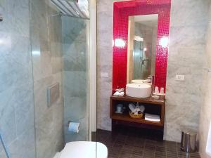 a bathroom with a shower and a sink and a toilet at Torre Fiore Hotel Masseria in Pisticci