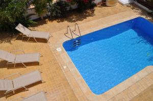 an overhead view of a swimming pool with two chairs at Poros 2 Villa in Protaras