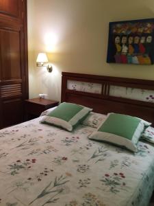 a bedroom with a bed with two green pillows at Apartamento El Muelle in Arrieta