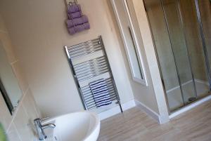 uma casa de banho com um lavatório e um chuveiro em The Sherwood em Skegness