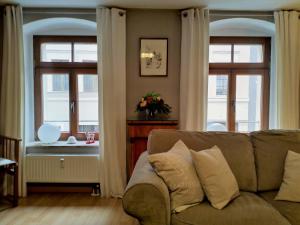 ein Wohnzimmer mit einem Sofa und 2 Fenstern in der Unterkunft Nonne8Appart in Görlitz