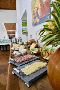 una mesa con queso y otros alimentos. en Pouso Alforria, en Tiradentes