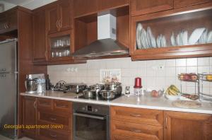 a kitchen with wooden cabinets and a stove top oven at Georgia's Family Apartment in Heraklio Town