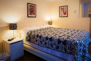 um quarto com uma cama com uma colcha azul e branca em Chalet Beaconsfield Motel em Beaconsfield