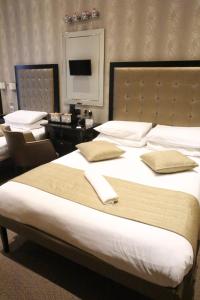 ロンドンにあるデューク オブ レンスター ホテルの大型ベッド1台、デスクが備わる客室です。