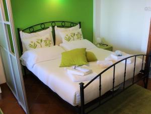 a bedroom with a bed with white sheets and green walls at Villa Sofia in Taormina