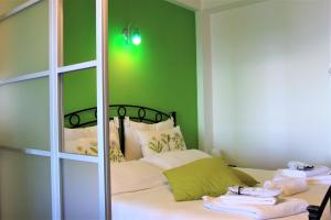 a bedroom with a bed with green walls and a mirror at Villa Sofia in Taormina