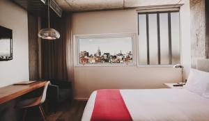a bedroom with a bed and a desk and a window at Nolitan Hotel SoHo - New York in New York