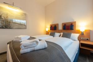 Dos camas en una habitación de hotel con toallas. en Hotel Werk II, en Bocholt