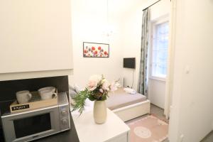 ブダペストにあるReal Apartments Wesselényi IVのベッド1台と花瓶が備わる小さなお部屋です。
