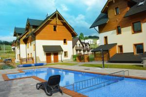 a swimming pool with a chair in front of a house at Przystań Góralska in Szczawnica