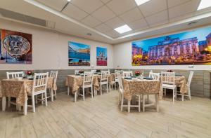 a room with tables and chairs and paintings on the walls at Hotel Balilla in Rome