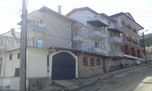 a building with a blue door on the side of a street at На гости при Силвия in Obzor