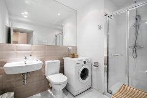 a bathroom with a toilet sink and a washing machine at Art Studios - LoftAffair in Kraków