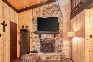 a living room with a stone wall with a tv at Redwood Commons B12 in Angel Fire
